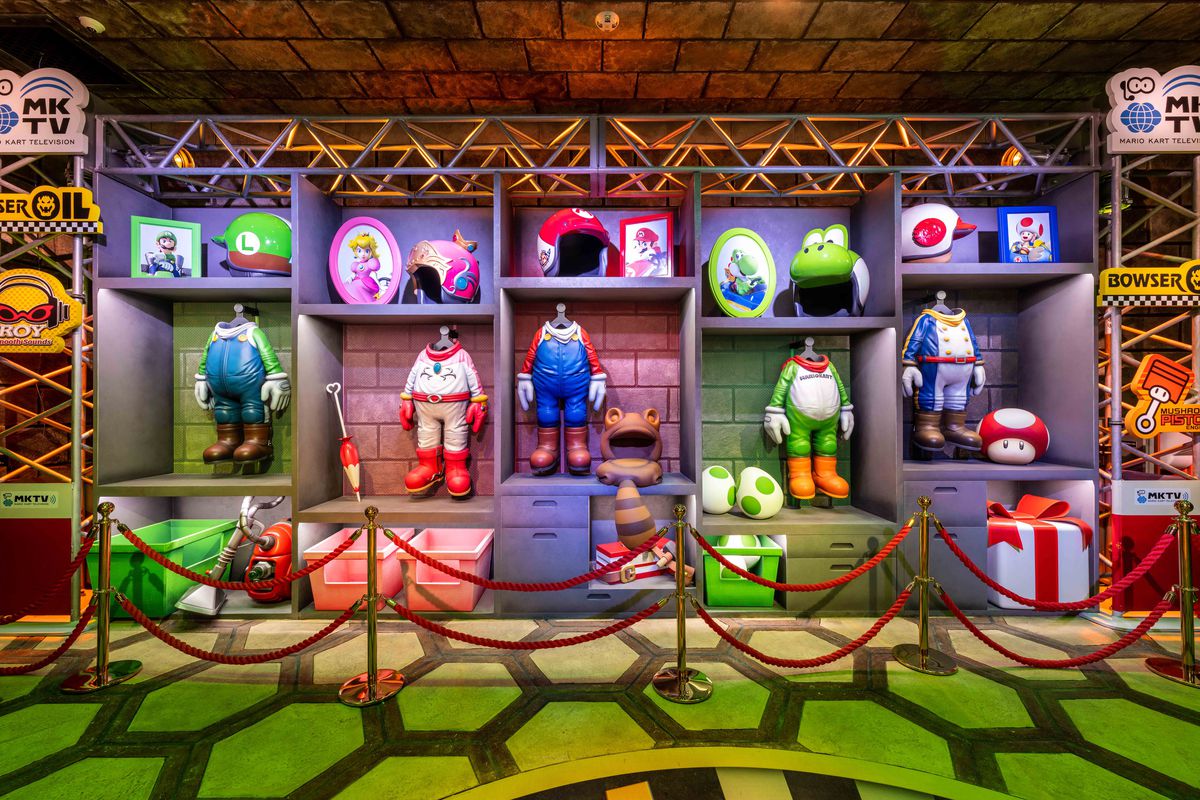 A photo from Super Nintendo World’s Mario Kart ride, which shows Mario, Luigi, Peach, Yoshi, and Toad’s karting outfits and helmet.